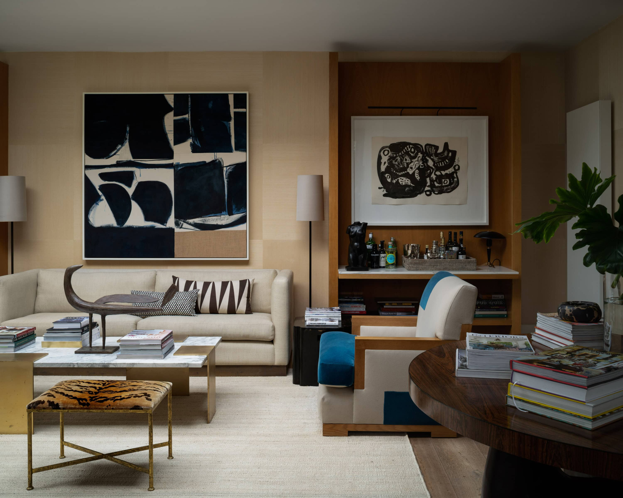 Modern living room with abstract art, cosy seating, and stylish decor.