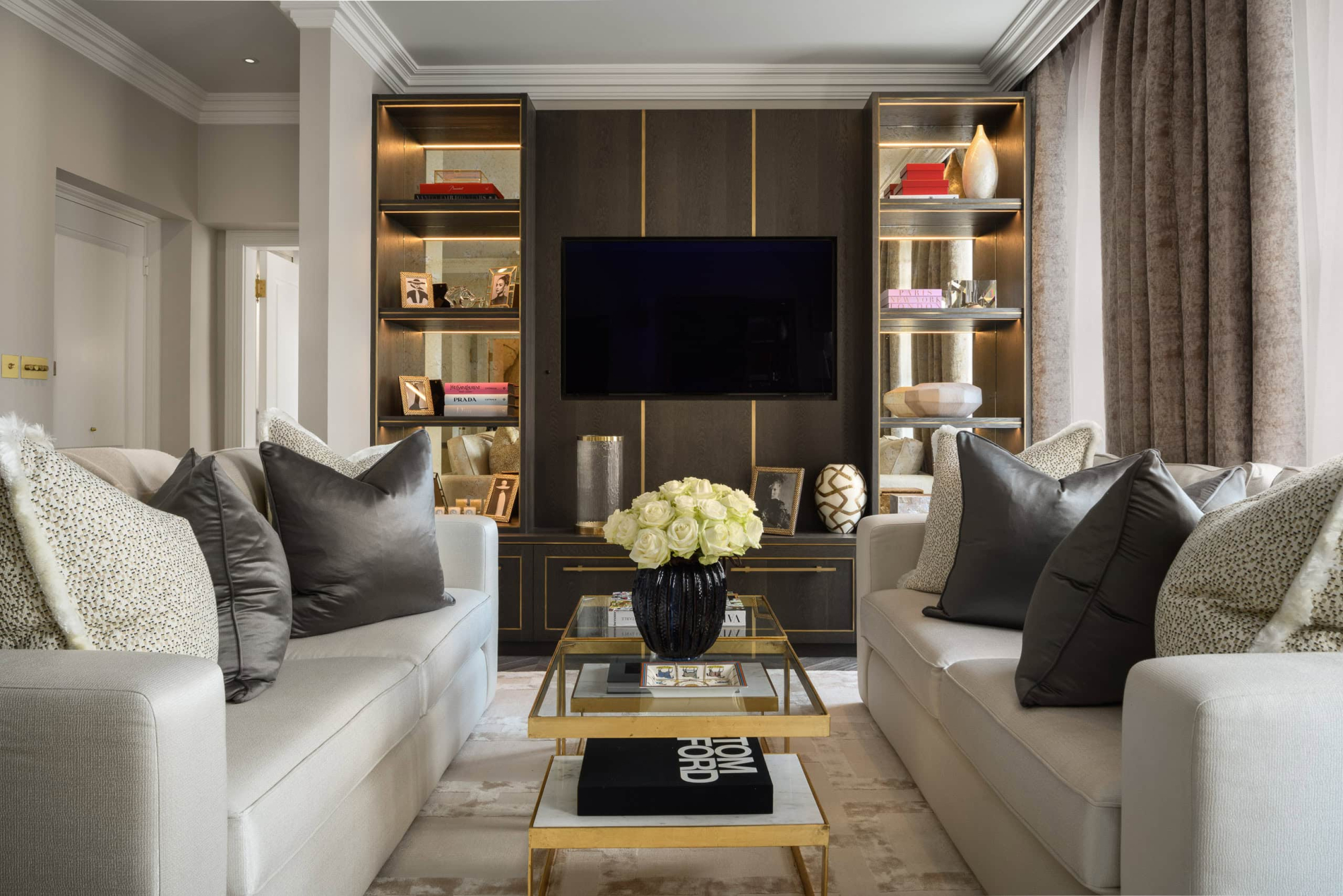 Modern living room with built-in bookshelves, wall-mounted TV, and elegant decor.